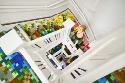 Couple returning to hotel room on colorful staircase - Professional Photographer Lifestyle Photography Wardrobe Stylist