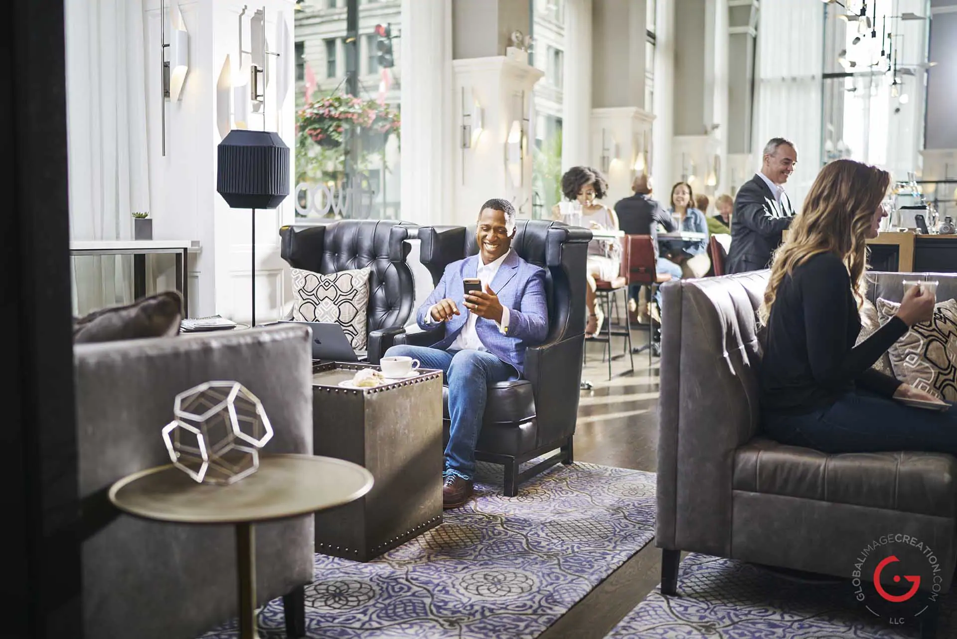 Man enjoys text in a trendy hotel lobby - Professional Photographer Lifestyle Photography Wardrobe Stylist