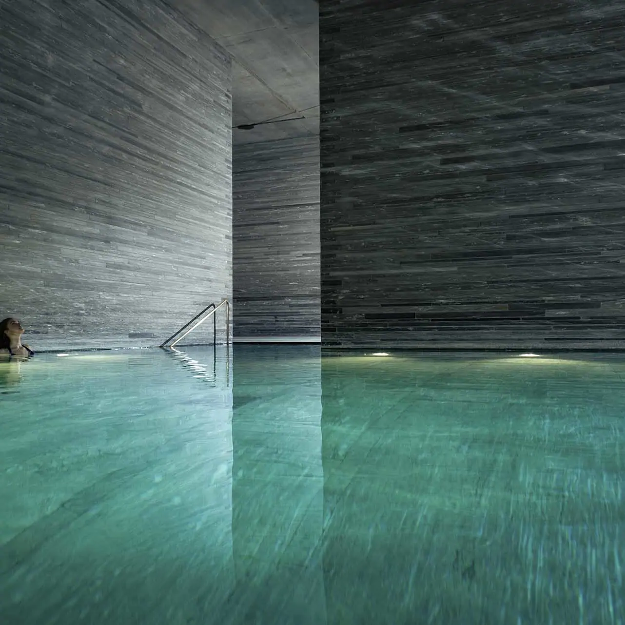 Woman has a Moment of Solace in the 7132 Hotel Therme by Peter Zumthor - Professional Photographer Lifestyle Photography Wardrobe Stylist