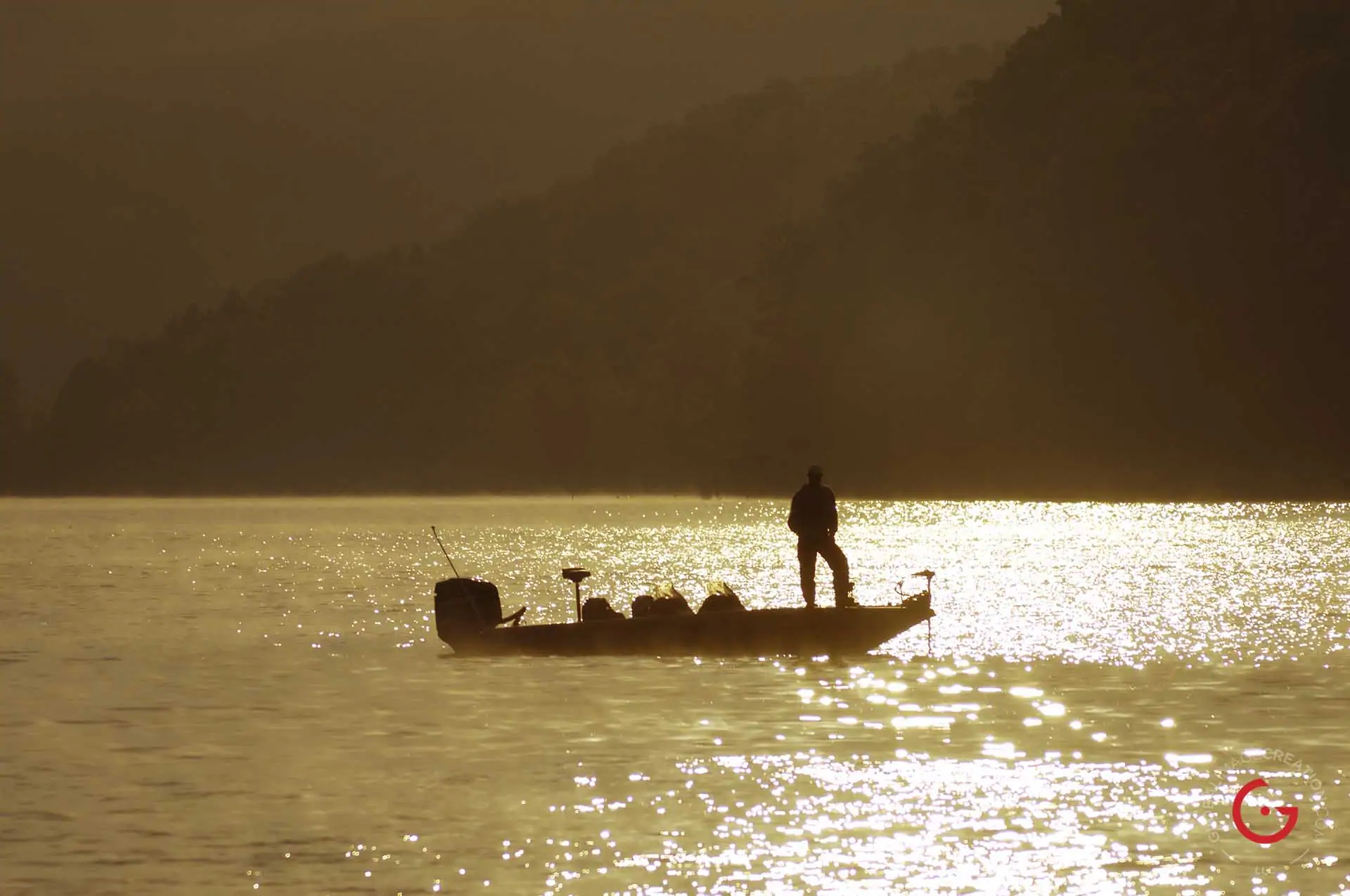 A man fishing boat in Table Rock Lake in the morning mist. Golden sunlight glistens on the water. - Advertising photographers in Branson Missouri, Branson Missouri photography