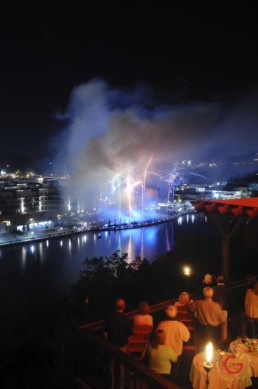Diners gather on a balcony overlooking the Branson Landing to enjoy fireworks over lake Tanycomo. - Advertising photographers in Branson Missouri, Branson Missouri photography