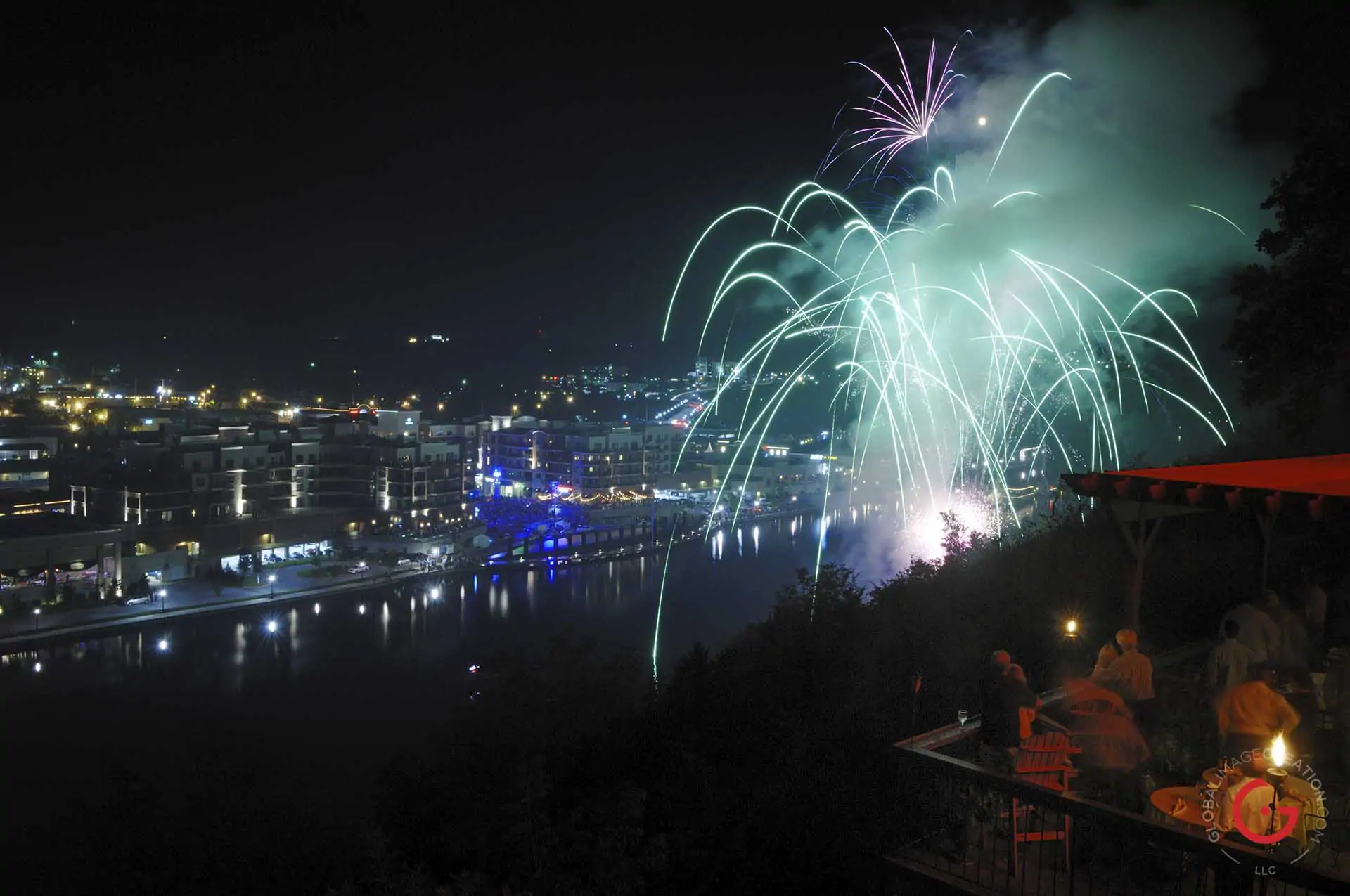 Diners gather on a balcony overlooking the Branson Landing to enjoy fireworks over lake Tanycomo. - Advertising photographers in Branson Missouri, Branson Missouri photography