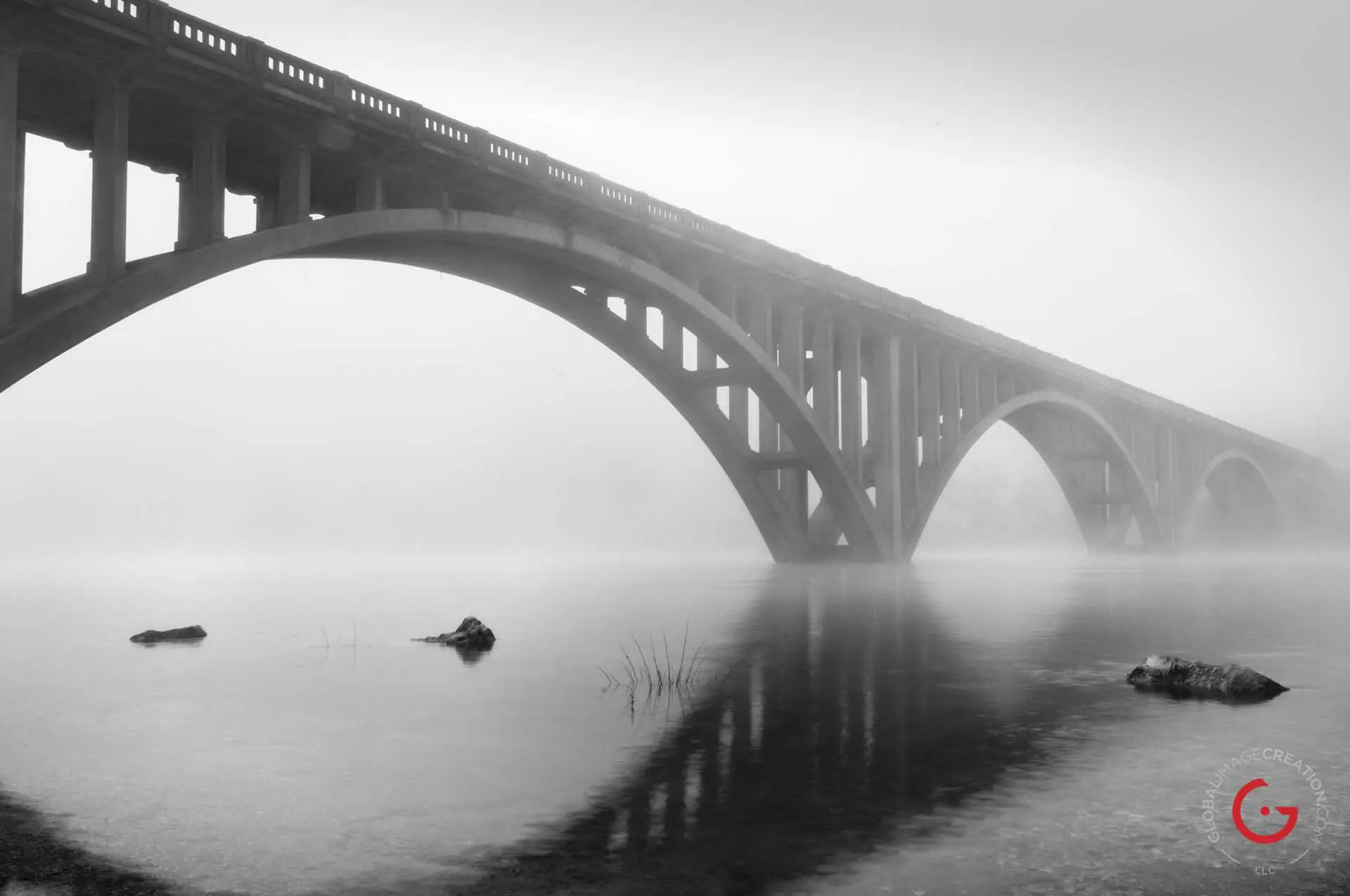 Early morning fog casts the downtown Branson bridge in dim ghostly light while the water on lake Tanycomo reflects like a mirror. - Advertising photographers in Branson Missouri, Branson Missouri photography