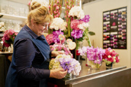 Florist Loren Fisher puts the finishing touches on a hotel room floral arrangement..